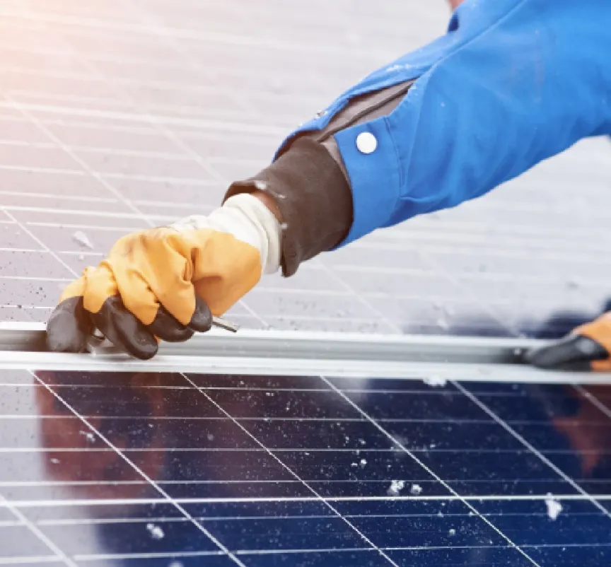太陽光発電をグローブをはめた作業員が作業をしている写真